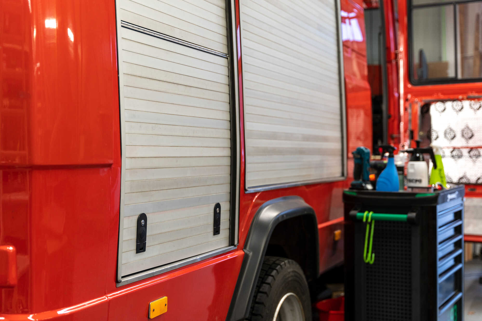 Hinteres Rolltor mit maßgefertigter Stauraumklappe im Mercedes T2 Feuerwehr Camper