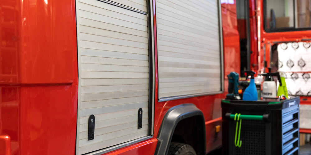 Hinteres Rolltor mit maßgefertigter Stauraumklappe im Mercedes T2 Feuerwehr Camper